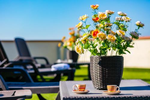 a vase of flowers sitting on a table with two cups at Culture Residence Consalvo Otto in Naples