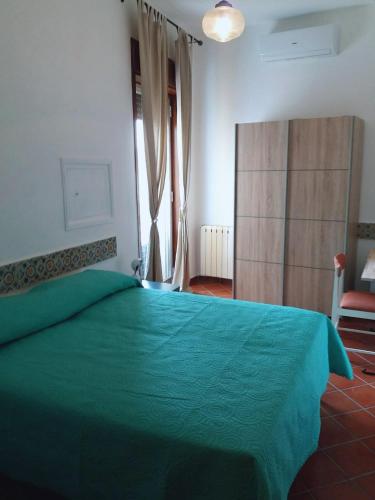 a bedroom with a green bed and a window at Miscalè House in Cattolica Eraclea