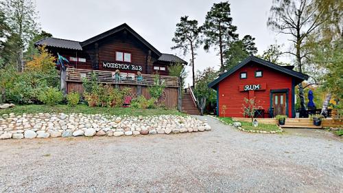 Una cabaña roja con un cartel en la parte delantera. en Woodstock B & B Studios, en Bålsta