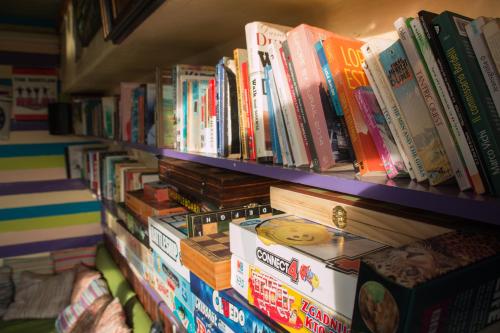 a book shelf filled with lots of books at The Flying Pig Beach Hostel in Noordwijk aan Zee