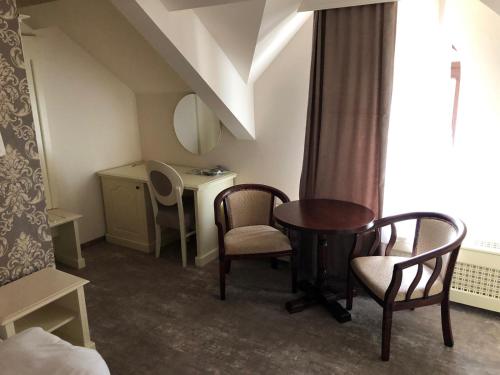 a room with a table and chairs and a desk at Ana Boutique in Alba Iulia