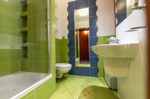 a bathroom with a toilet and a sink and a shower at Victus Apartamenty, Apartament Avocado in Sopot