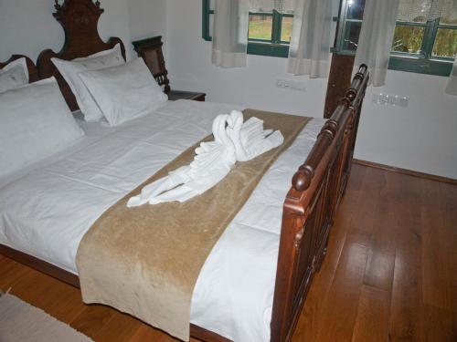 Una cama con sábanas blancas y toallas. en Stara Iža en Selišće Sunjsko