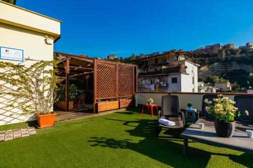 a rooftop garden with a patio and grass at Culture Residence Consalvo Otto in Naples