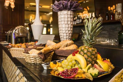 a buffet with a pineapple and other fruits on a counter at Duna Garden Hotel in Budapest