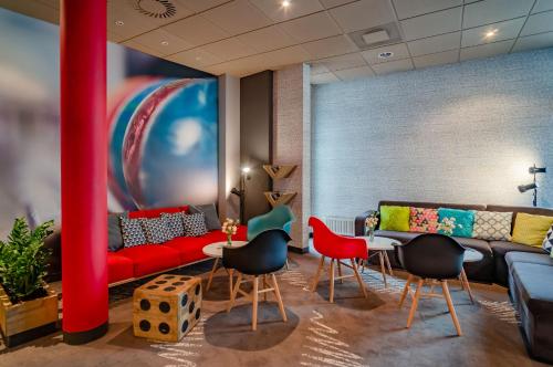 a living room with a red couch and chairs at Ibis Częstochowa in Częstochowa