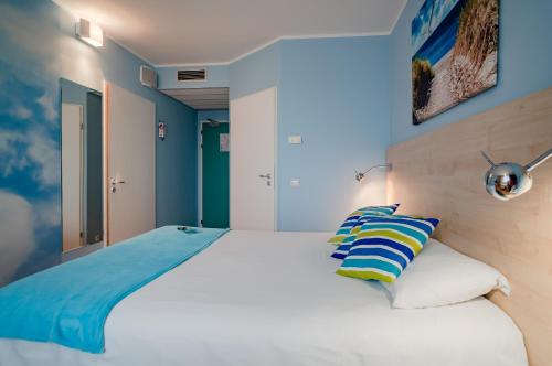 a bedroom with a large white bed with blue walls at Ibis Częstochowa in Częstochowa