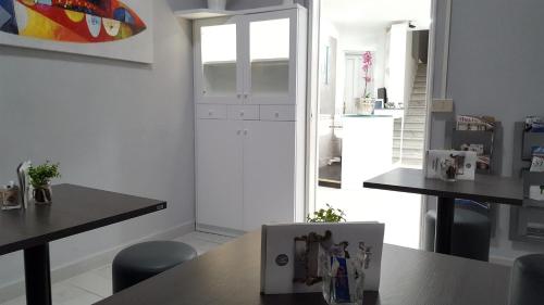 a kitchen with white walls and tables and chairs at Hotel Milano in Pisa
