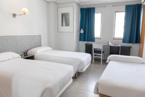 A bed or beds in a room at Hotel Alda Centro Palencia