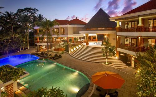 an outdoor swimming pool in front of a building at Green Field Resort Ubud in Ubud