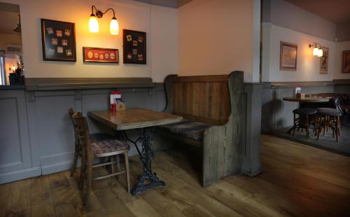 a wooden table in a room with a lamp at The Horse & Farrier in Otley
