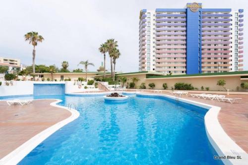 une grande piscine en face d'un grand bâtiment dans l'établissement Les Vacances Au Club Paraiso, à Playa Paraiso