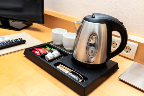 a tea kettle sitting on top of a desk at Urdlwirt - Hotel & Restaurant in Premstätten