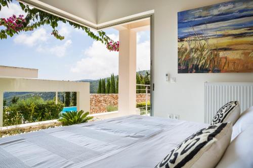 Schlafzimmer mit einem großen Fenster und einem Bett in der Unterkunft Sterna Villa - Contemporary Villa with Private Pool & Sea Views, Fiskardo in Fiskardo