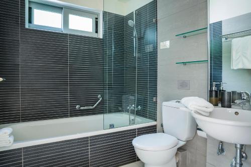 ein Badezimmer mit einem WC, einer Badewanne und einem Waschbecken in der Unterkunft Sterna Villa - Contemporary Villa with Private Pool & Sea Views, Fiskardo in Fiskardo