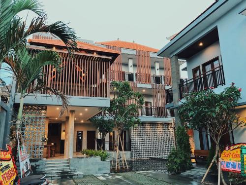 a building with palm trees in front of it at Perissos Echo Beach in Canggu