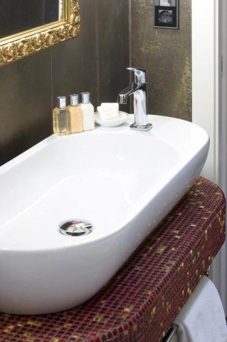 a white sink in a bathroom with a mirror at Parc Hotel Flora S in Riva del Garda