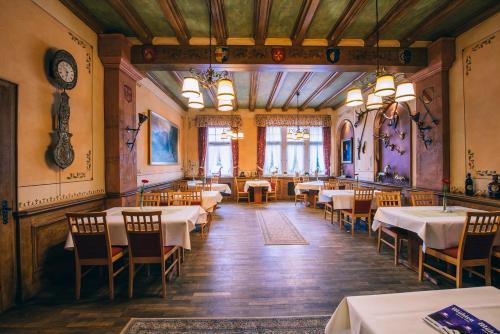 comedor con mesas y sillas y reloj en Hotel Dammenmühle en Lahr