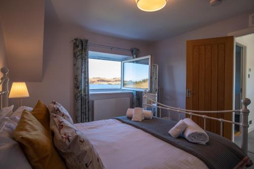 a bedroom with a bed with two towels on it at Lochside in Staffin