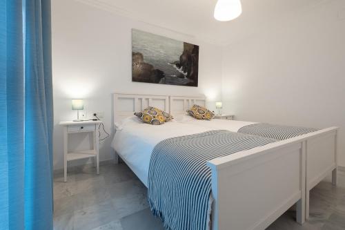 1 dormitorio con 2 camas y un cuadro en la pared en Duplex La Corrala, en Cádiz