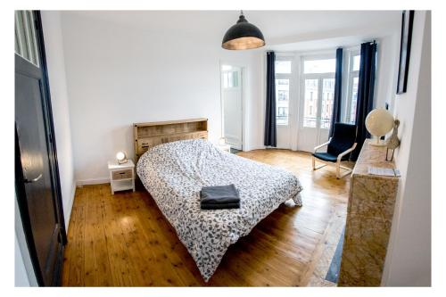 1 dormitorio con 1 cama y 1 silla en Grand appart 85m2 de standing, hyper centre/gare, en Lille