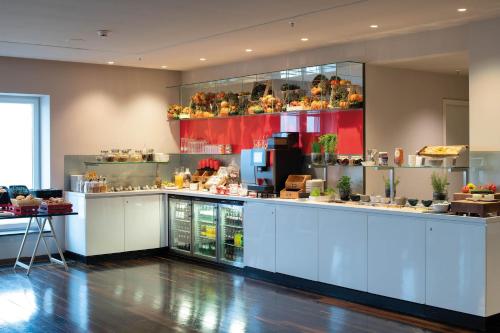 a large kitchen with a counter with food at Vienna House by Wyndham Andel's Berlin in Berlin