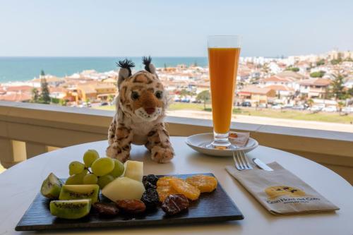 
a teddy bear sitting on a table next to a plate of food at Gran Hotel del Coto in Matalascañas
