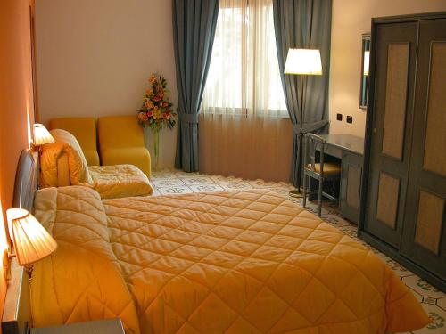 マリーナ・ディ・ヴァルカトゥロにあるHotel L' Anicrèのベッドルーム(オレンジ色のベッド1台、デスク付)