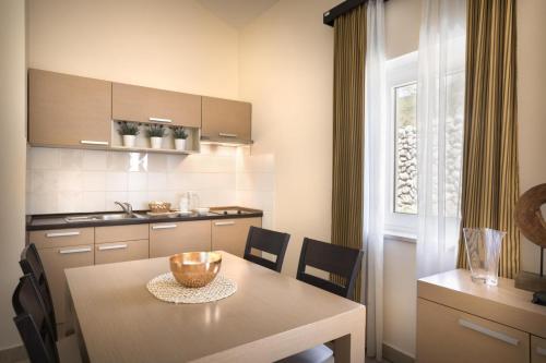 a kitchen with a table and chairs and a dining room at Apartment ACI Marina CRES in Cres