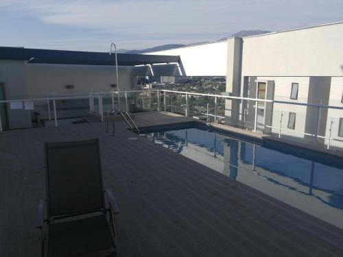 a rooftop deck with a swimming pool on a building at Excelente departamento en Las Condes in Santiago