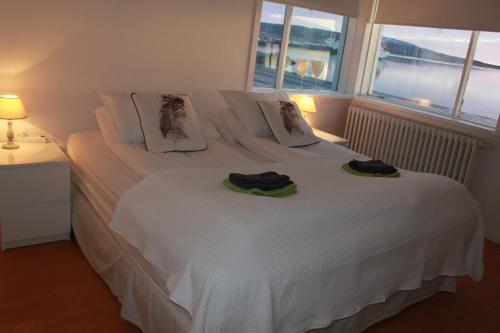 a bedroom with a white bed with two towels on it at Kriukot in Hólmavík