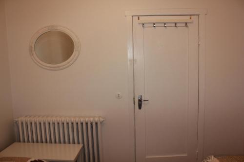 a white door in a room with a mirror at Kriukot in Hólmavík