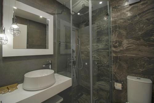 a bathroom with a sink and a glass shower at Boutique Apartments Blagoevgrad in Blagoevgrad