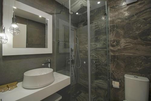 ein Bad mit einem Waschbecken und einer Glasdusche in der Unterkunft Boutique Apartments Blagoevgrad in Blagoewgrad