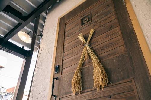 een houten deur met een hoop hooi erop bij Ise Guest House Kazami in Ise