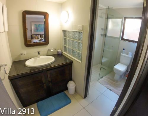 een badkamer met een wastafel en een glazen douche bij San Lameer Villas Three Bedroom --&-- Two Bedroom in Southbroom