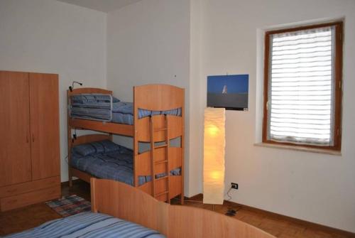 - une chambre avec 2 lits superposés et une fenêtre dans l'établissement Appartamenti Palazzo Lazzaris - Costantini - Dolomiti del Cadore, à Perarolo di Cadore