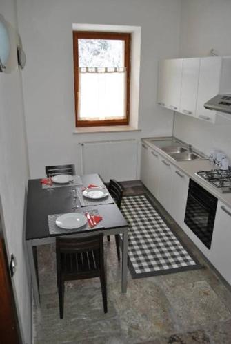 a small kitchen with a table and a sink at Appartamenti Palazzo Lazzaris - Costantini - Dolomiti del Cadore in Perarolo di Cadore