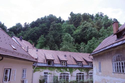a row of buildings with trees in the background at Harmony Gallery in Ljubljana