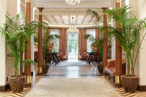 a hallway with potted plants in a building at Mount Nelson, A Belmond Hotel, Cape Town in Cape Town