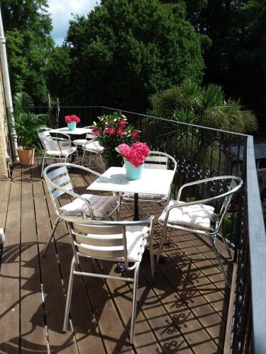 a row of tables and chairs on a balcony with flowers at Chine Side in Shanklin
