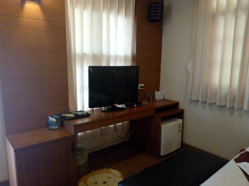 um quarto com uma secretária e uma televisão em Sisina Resort and Spa em Prachuap Khiri Khan