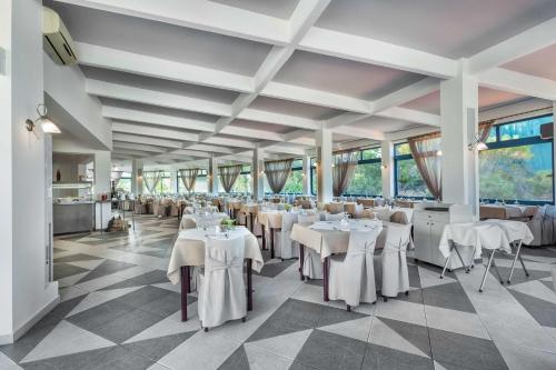 a banquet hall with white tables and chairs at Atrium Hotel in Pefkohori