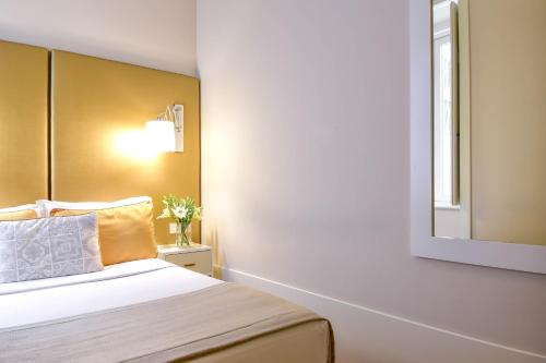 a bedroom with a bed with a mirror on the wall at My Story Hotel Ouro in Lisbon