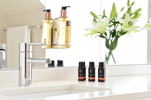 a bathroom sink with three bottles of essential oils on it at My Story Hotel Ouro in Lisbon