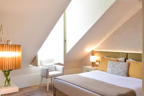 a bedroom with a bed and a chair at My Story Hotel Ouro in Lisbon