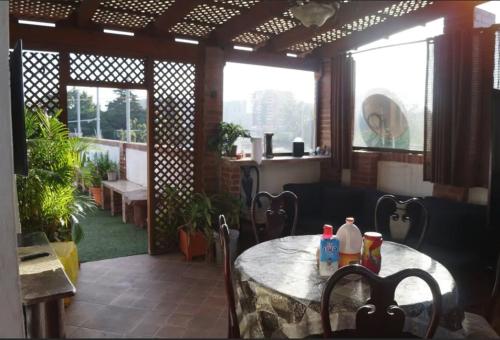 a patio with a table and chairs and windows at Apartamentos Comodos Cerca del Aeropuerto in Guatemala