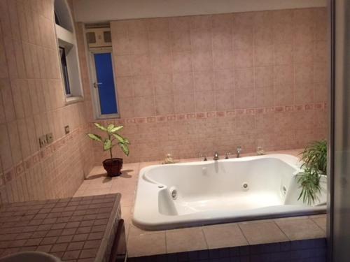 a white tub in a bathroom with a potted plant at Apartamentos Comodos Cerca del Aeropuerto in Guatemala