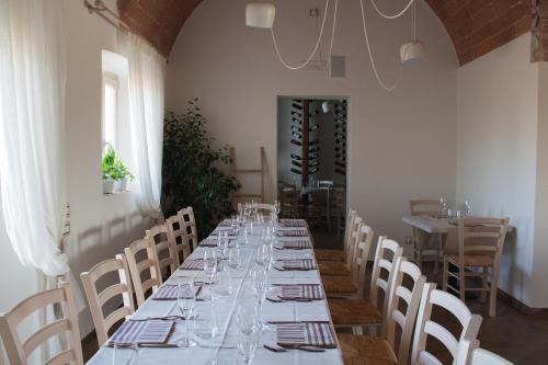 a long dining room with a long table with glasses at Fattoria L'Olmetto in Pisa