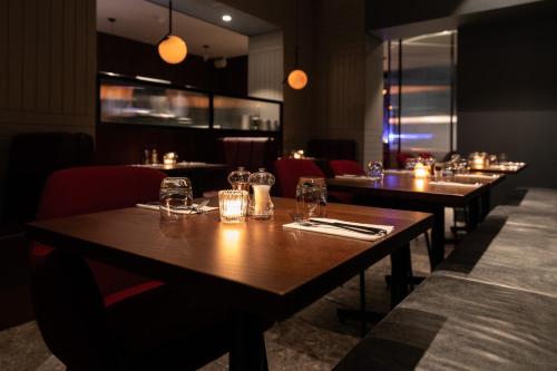 a row of tables in a restaurant with glasses on them at Euston Square Hotel in London